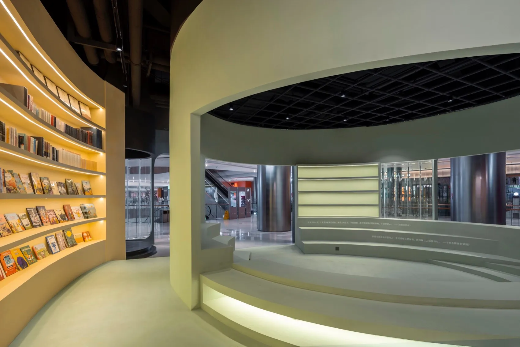A modern library interior featuring concrete stairs with embedded lighting.