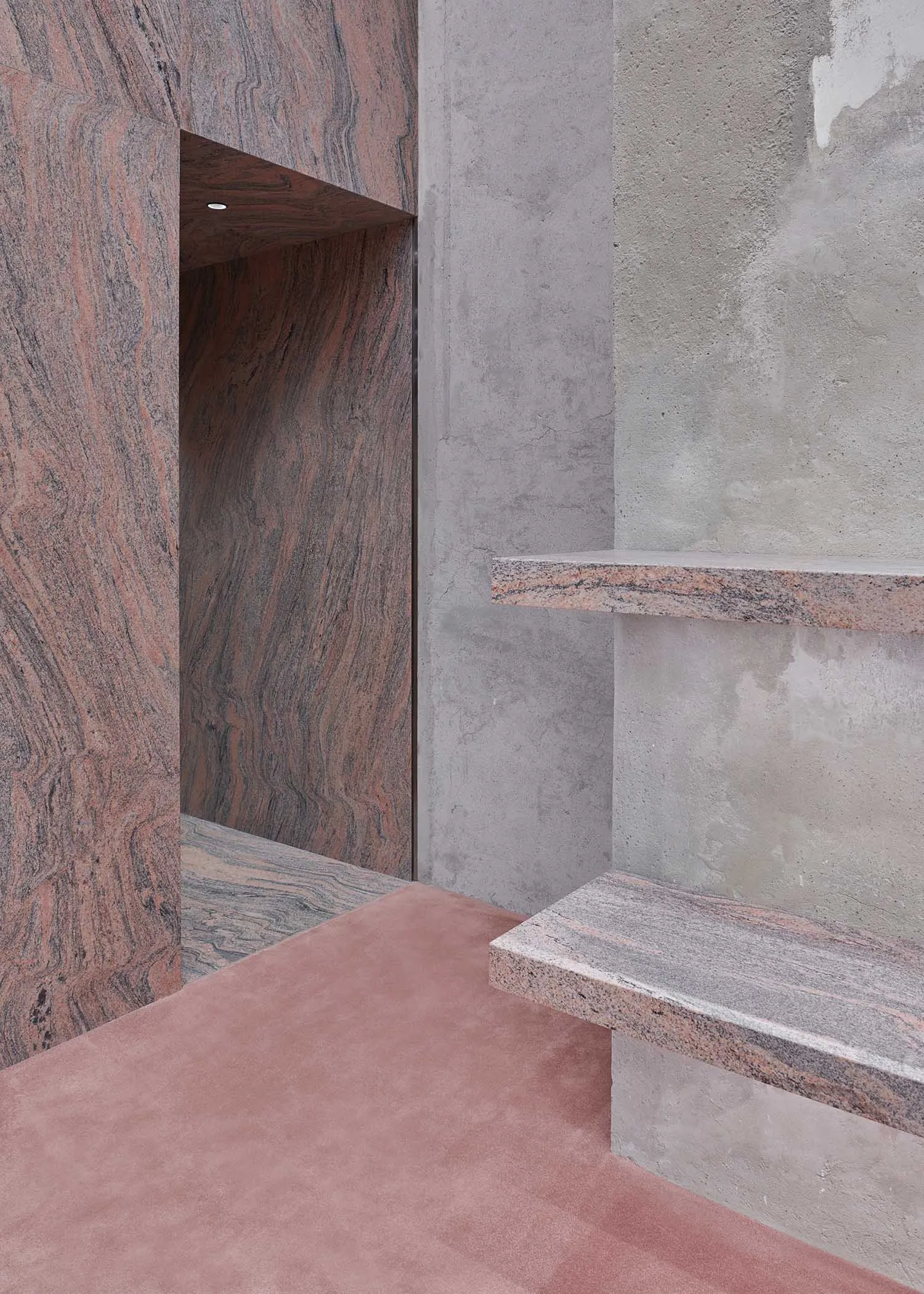 Modern interior design featuring textured granite walls and a smooth concrete floor.