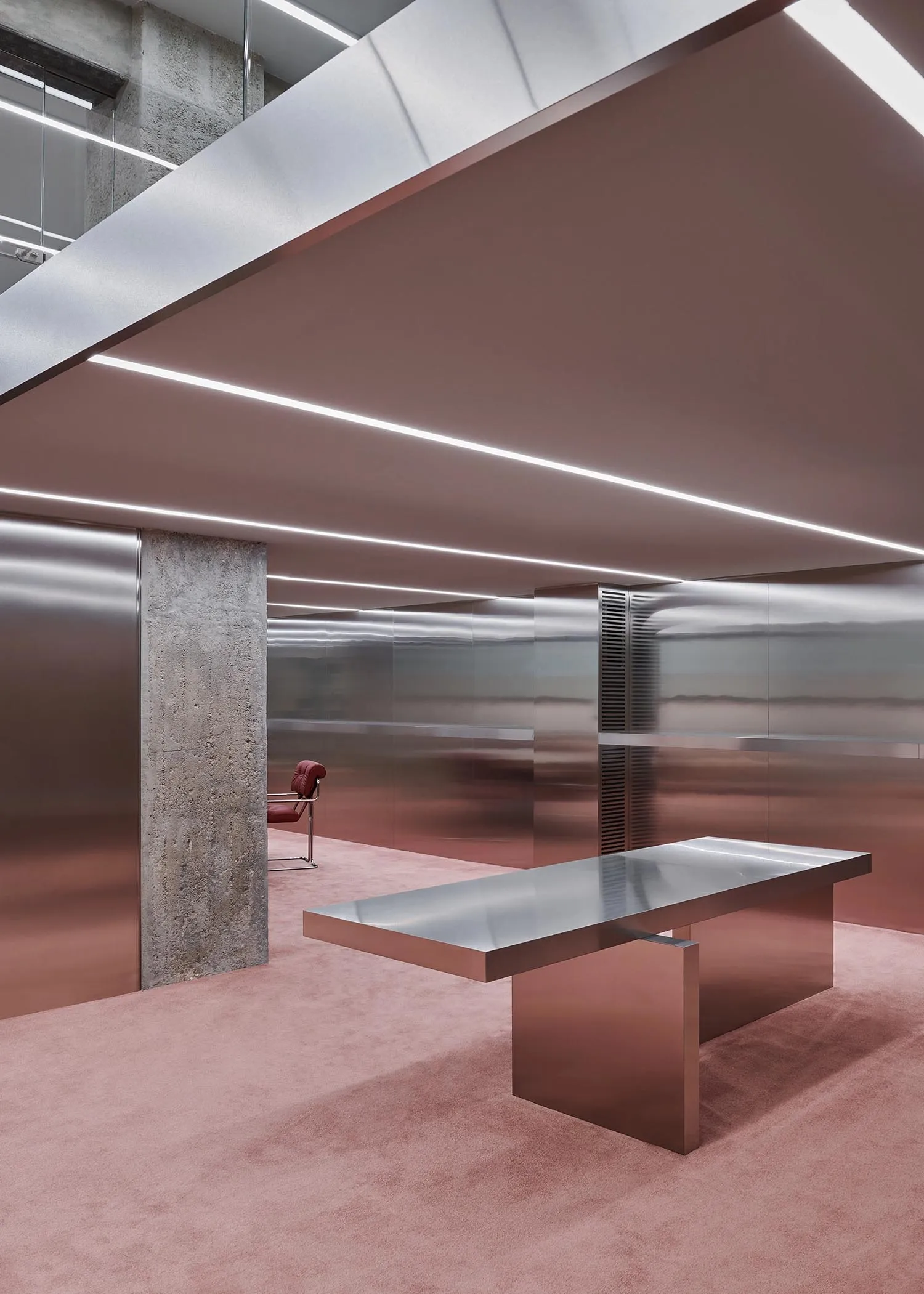 A minimalist office space featuring a metallic desk.