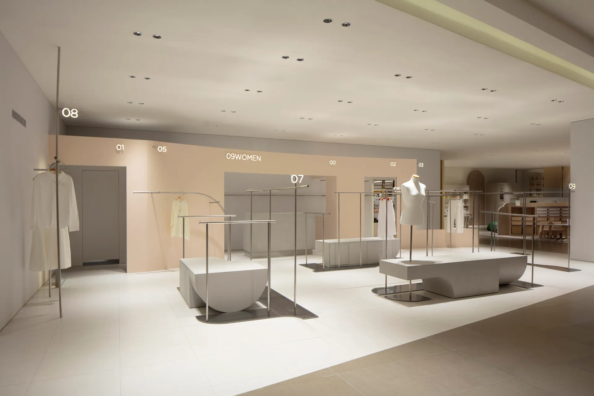 A minimalist retail store featuring white interiors with metal and concrete accents.
