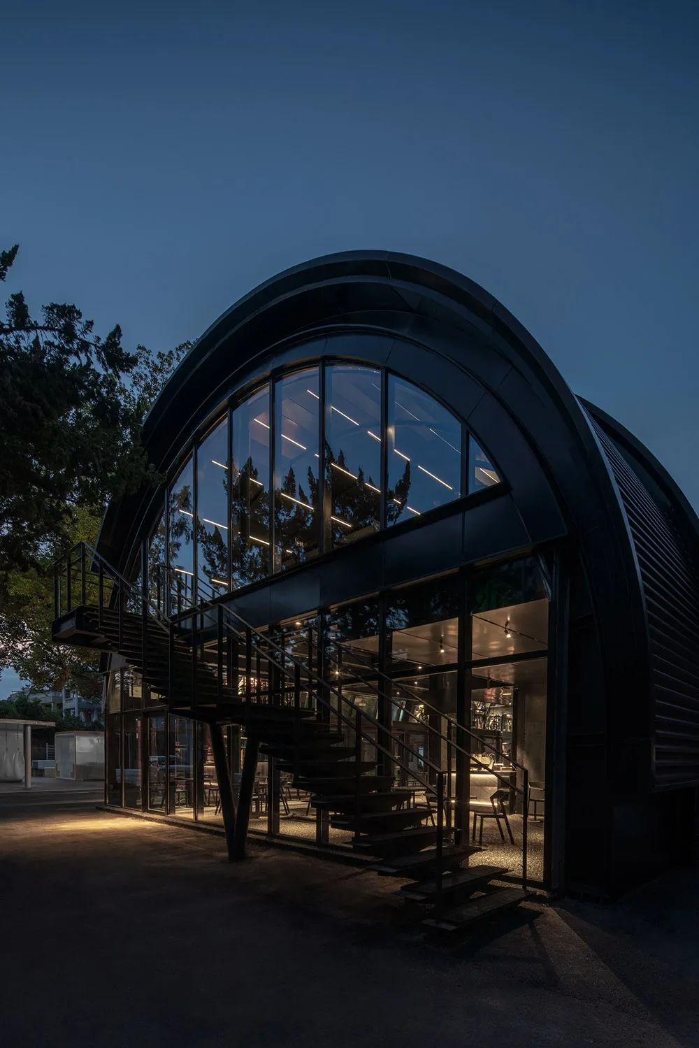 Modern glass front exterior of a bistro at dusk