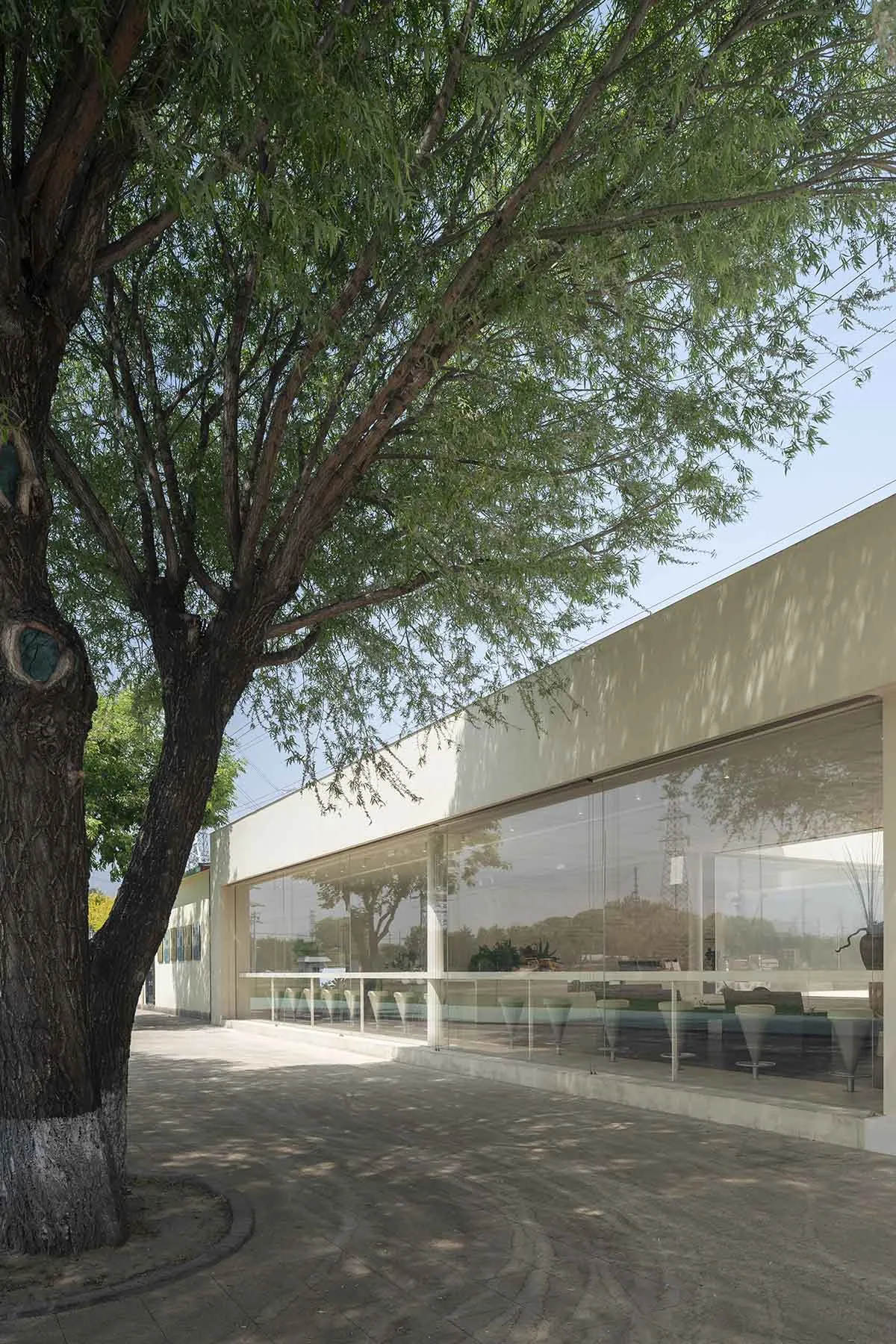 Modern commercial building with a glass facade and concrete elements.