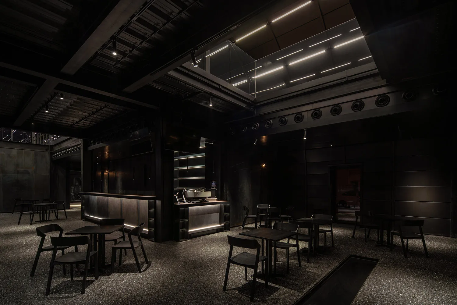 Industrial-themed restaurant interior with metallic finishes and dark color palette.