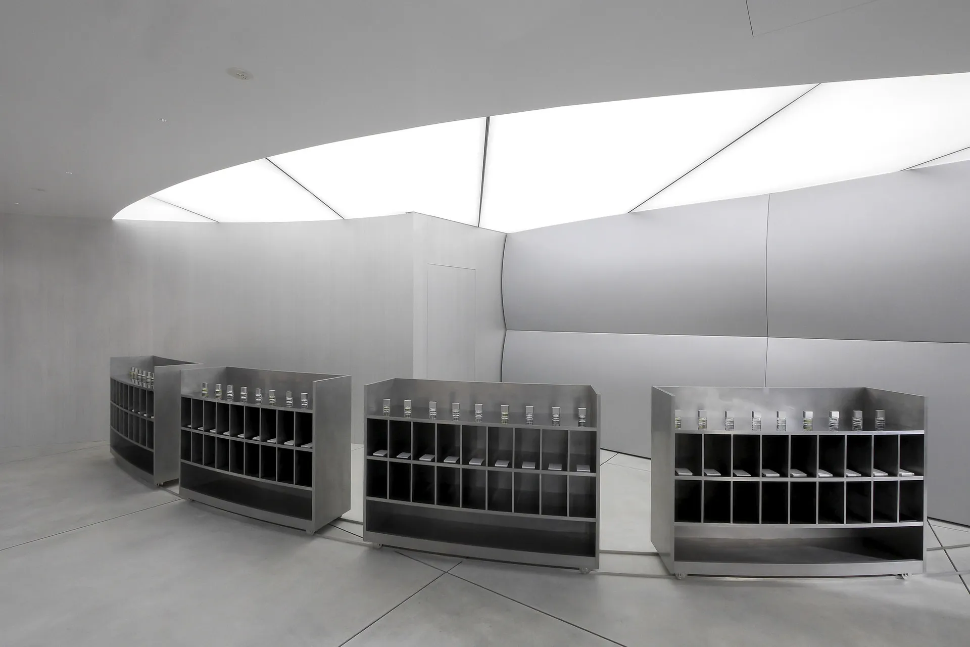 A minimalist exhibit space featuring metal shelves.