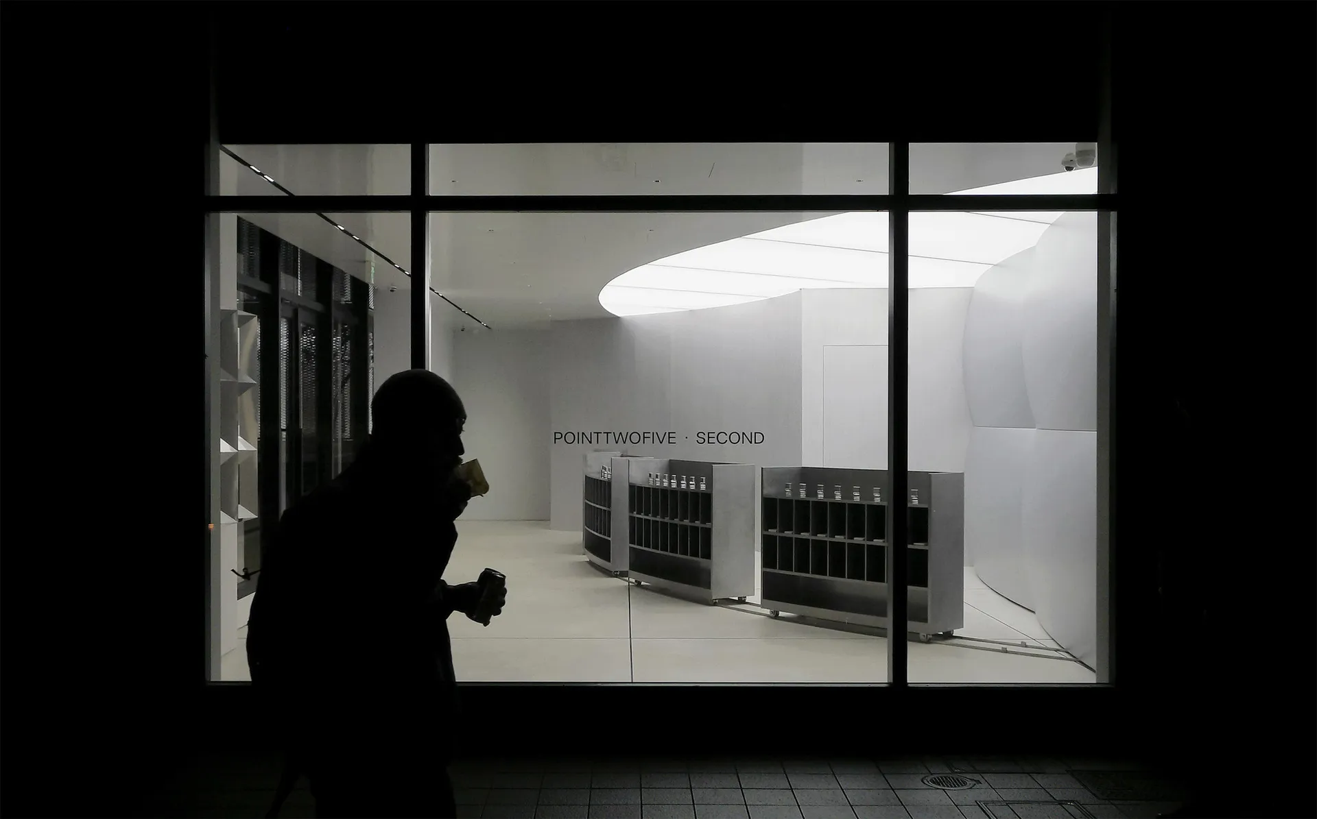 A minimalist retail space with a modern, sleek design featuring white lighting and white surfaces.