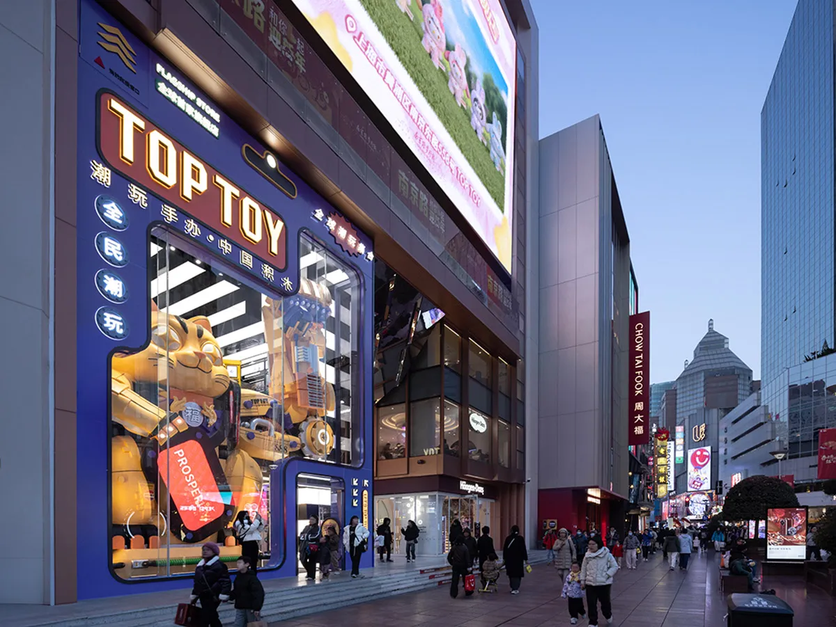 充滿活力的零售店面，藍色招牌上寫著「TOPTOY」，櫥窗內展示各種玩具。