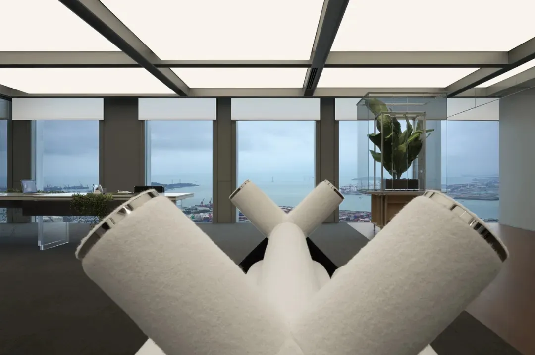 Modern office space featuring a desk with white towels and an open-plan design with large windows overlooking the cityscape.