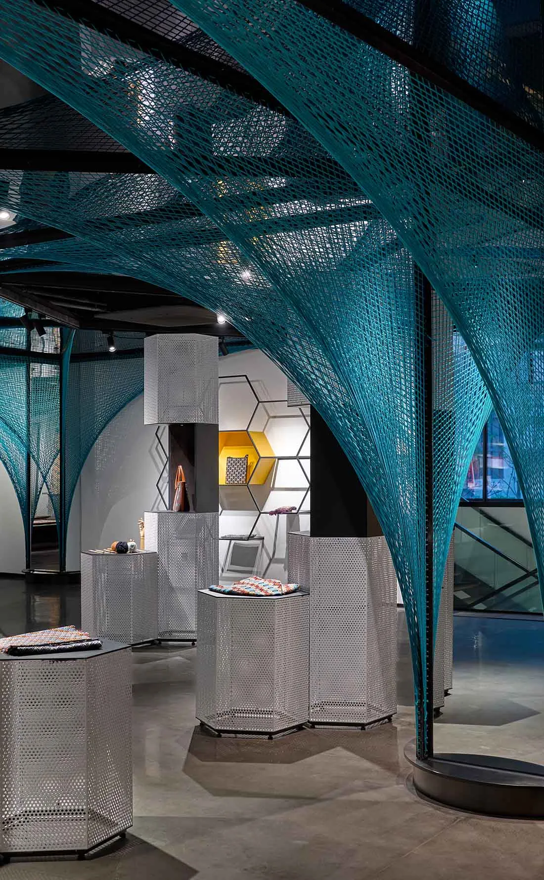 A modern retail space featuring metallic perforated panels and hexagonal structures.