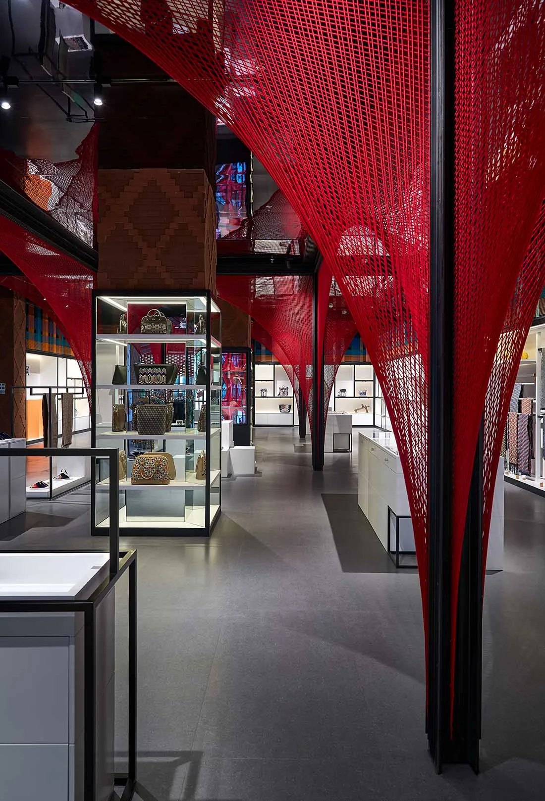 Modern retail space featuring red string lights hanging from the ceiling and black columns.