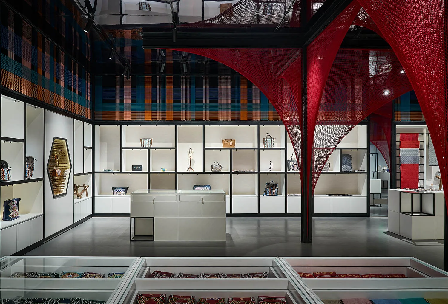 A modern retail store interior with fabric displays and glass shelves.