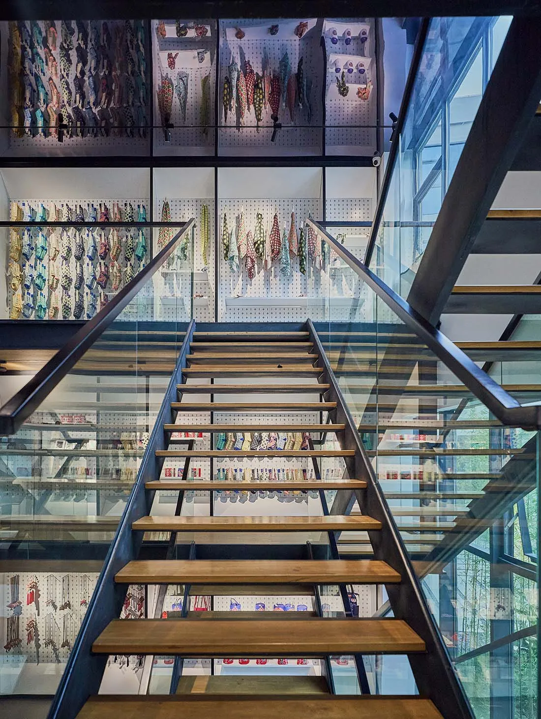 Industrial design retail storefront featuring glass, wooden shelves, and metal railings.