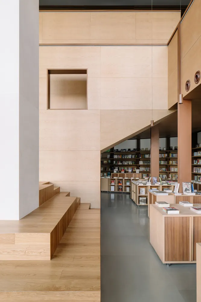 A minimalist library with wooden walls and shelves