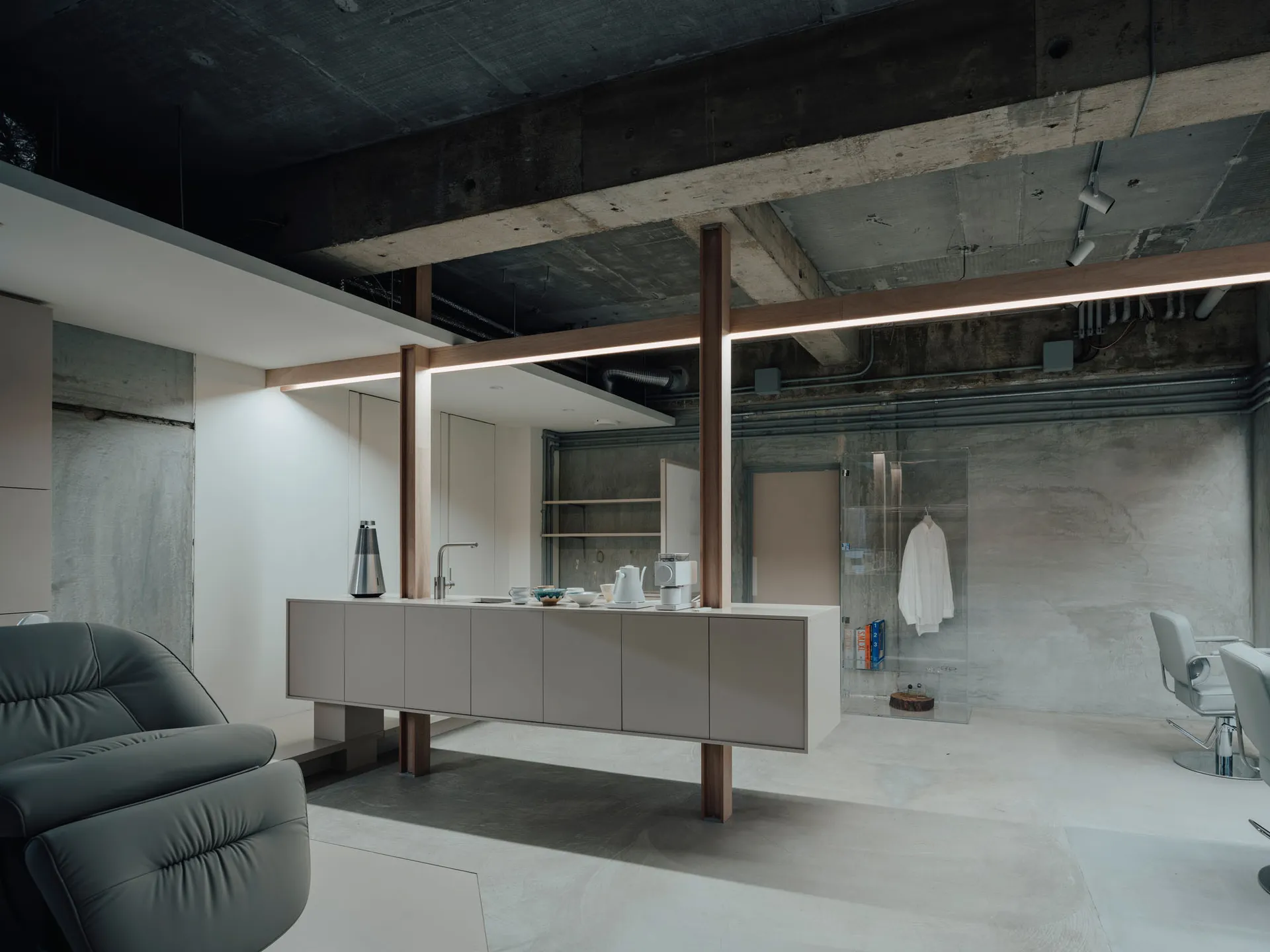 Modern, minimalist living, dining, and kitchen area with concrete walls and floor.