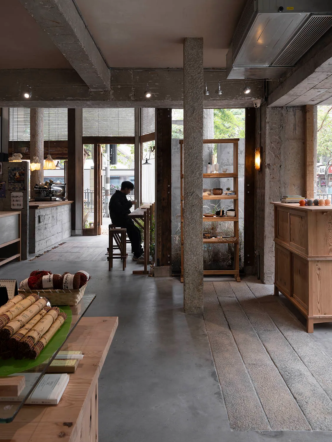 Interior of a coffee shop featuring concrete and wooden materials.