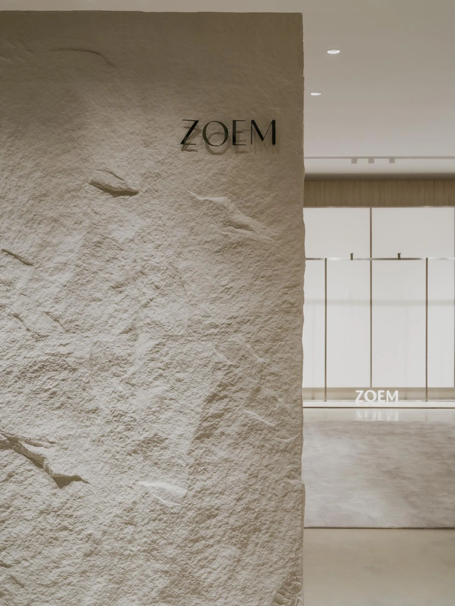 A minimalist interior design featuring a textured, concrete wall