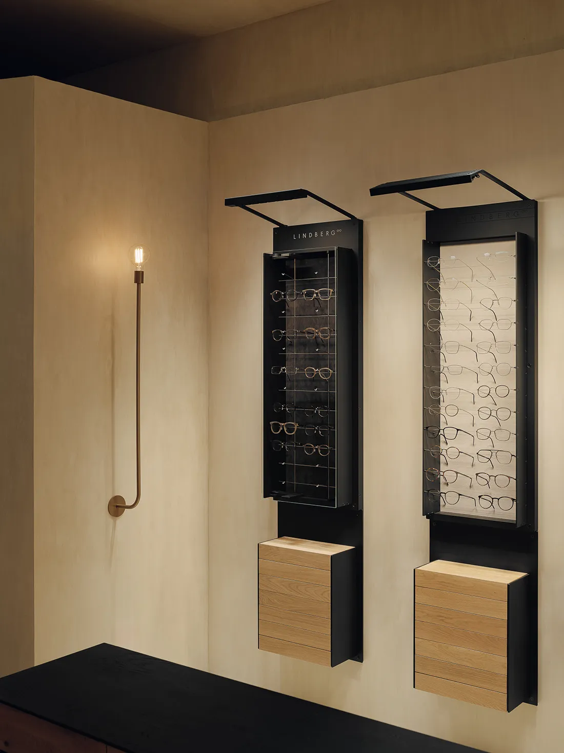 A minimalist eyewear display featuring metal and wooden frames in an optical shop.