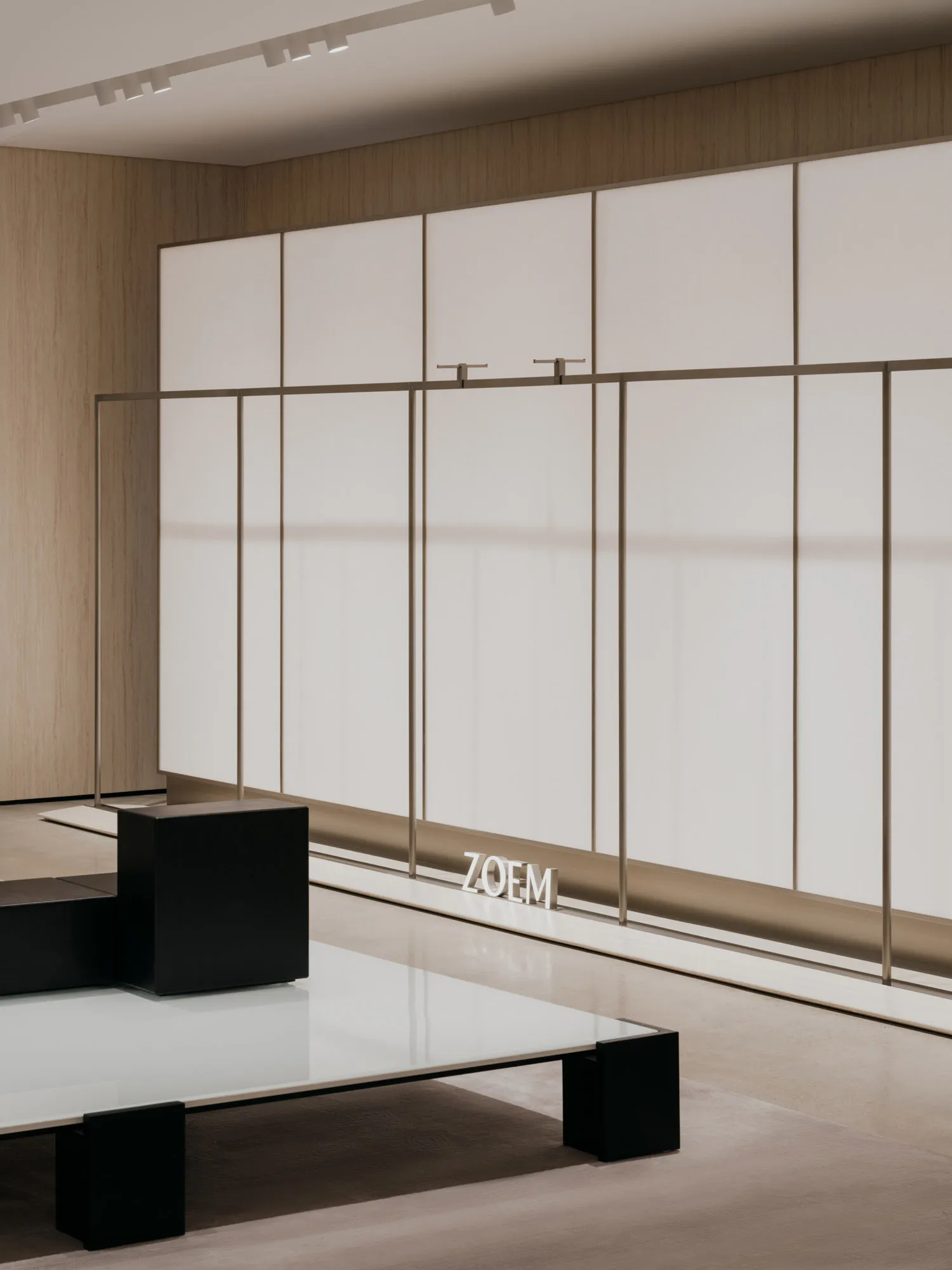 A minimalist showroom space with white surfaces and wood paneling.