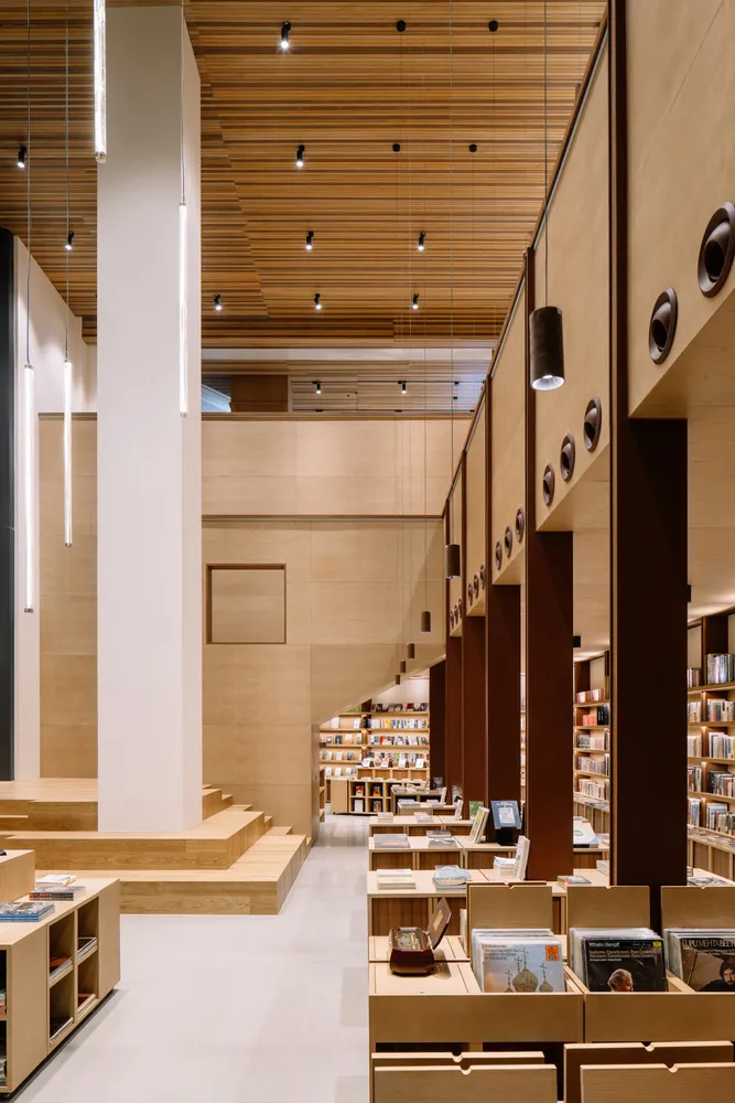現代圖書館空間,搭配木質書架與玻璃隔間。