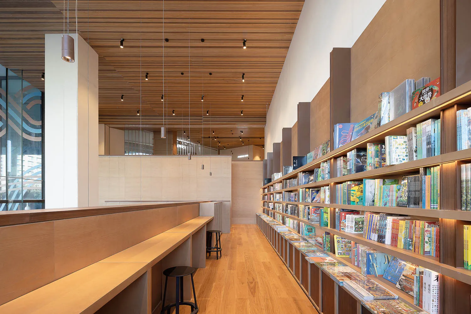 Modern library interior with wooden shelves and seating.