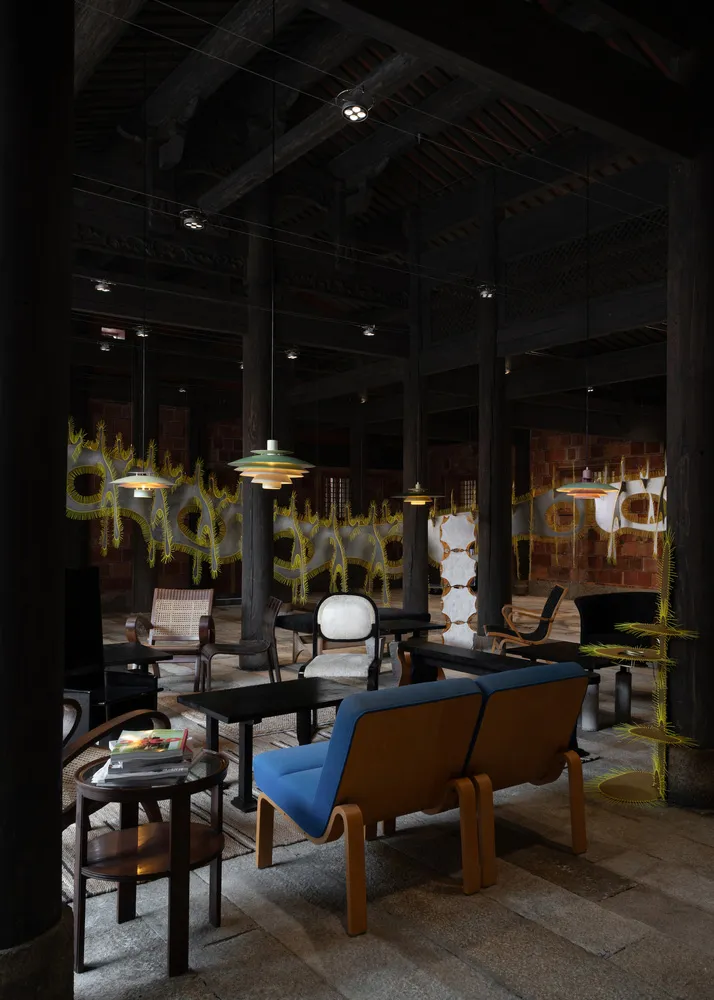 現代室內客廳,搭配木質家具、藍色沙發與吊燈。