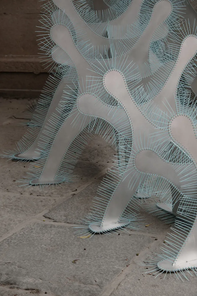 A contemporary metal sculpture with organic, wave-like forms.