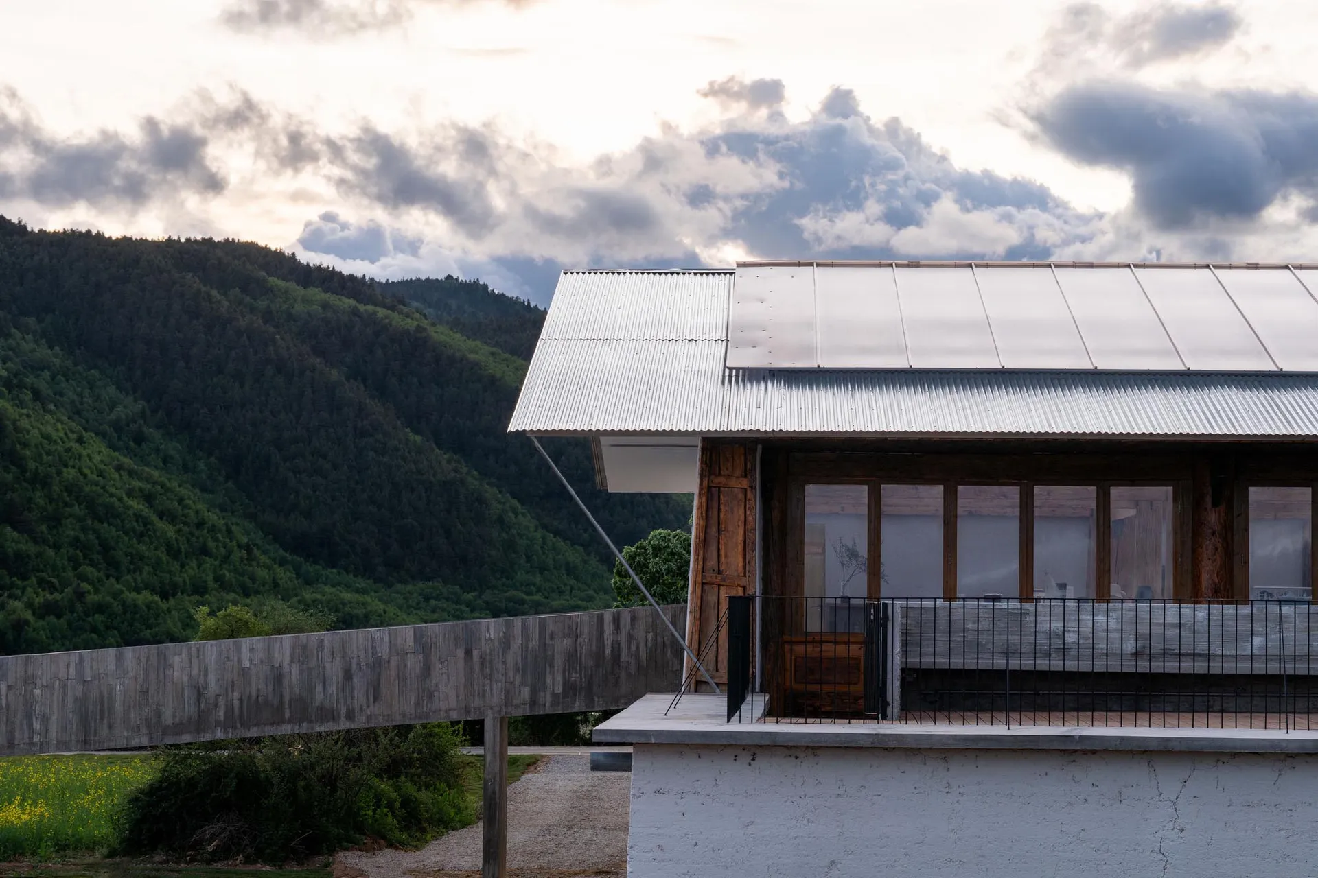 現代住宅外觀,搭配波浪金屬屋頂與混凝土基礎。