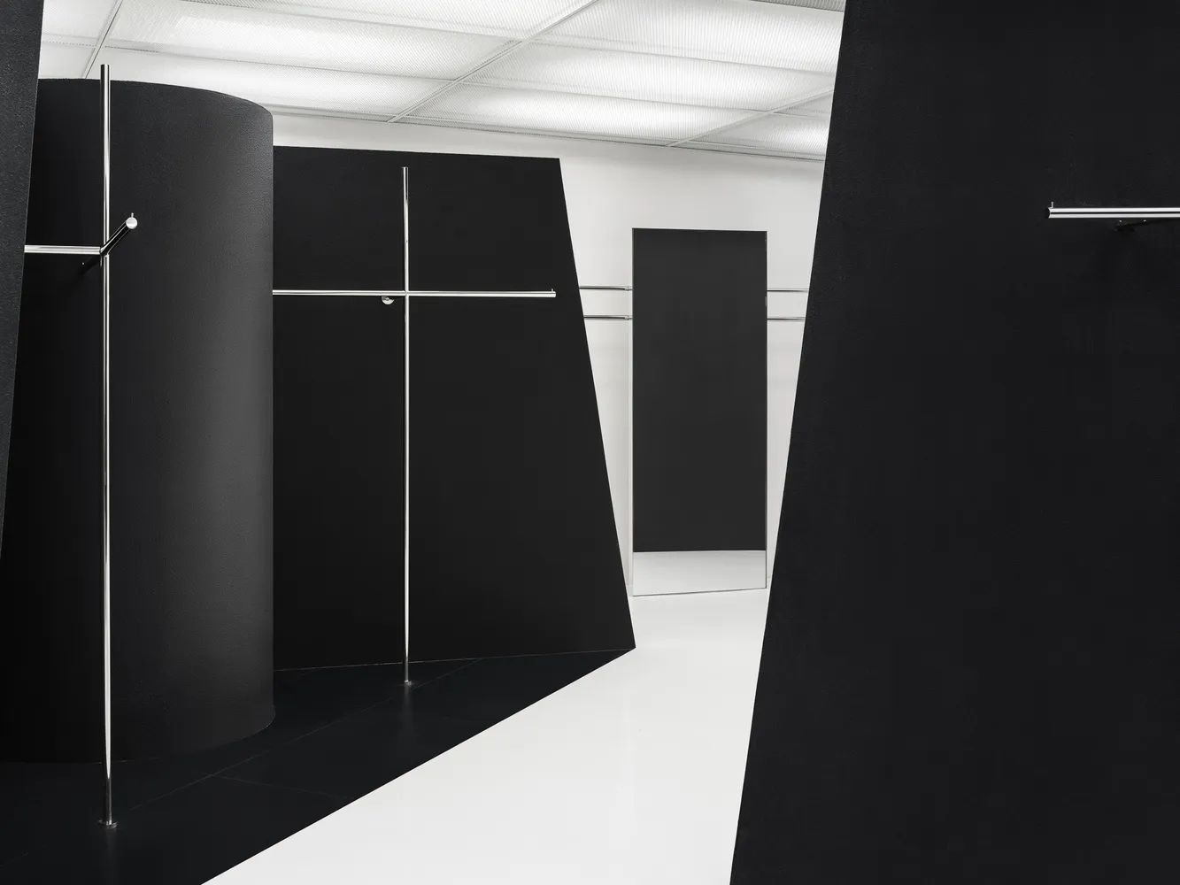 An abstract minimalist black and white interior space with geometric shapes and metallic accents.