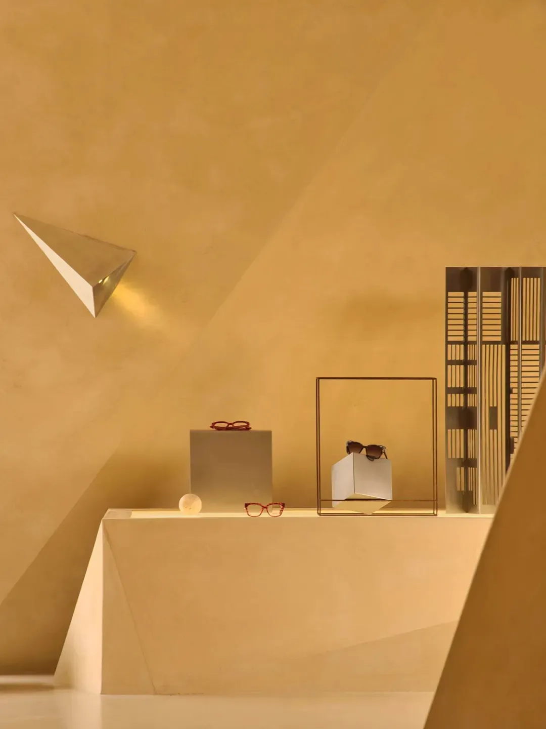 A modern retail storefront featuring metallic rectangular shapes and planes.