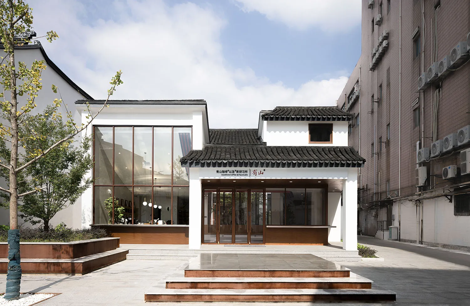 A modern coffee shop with a glass exterior and traditional roof.