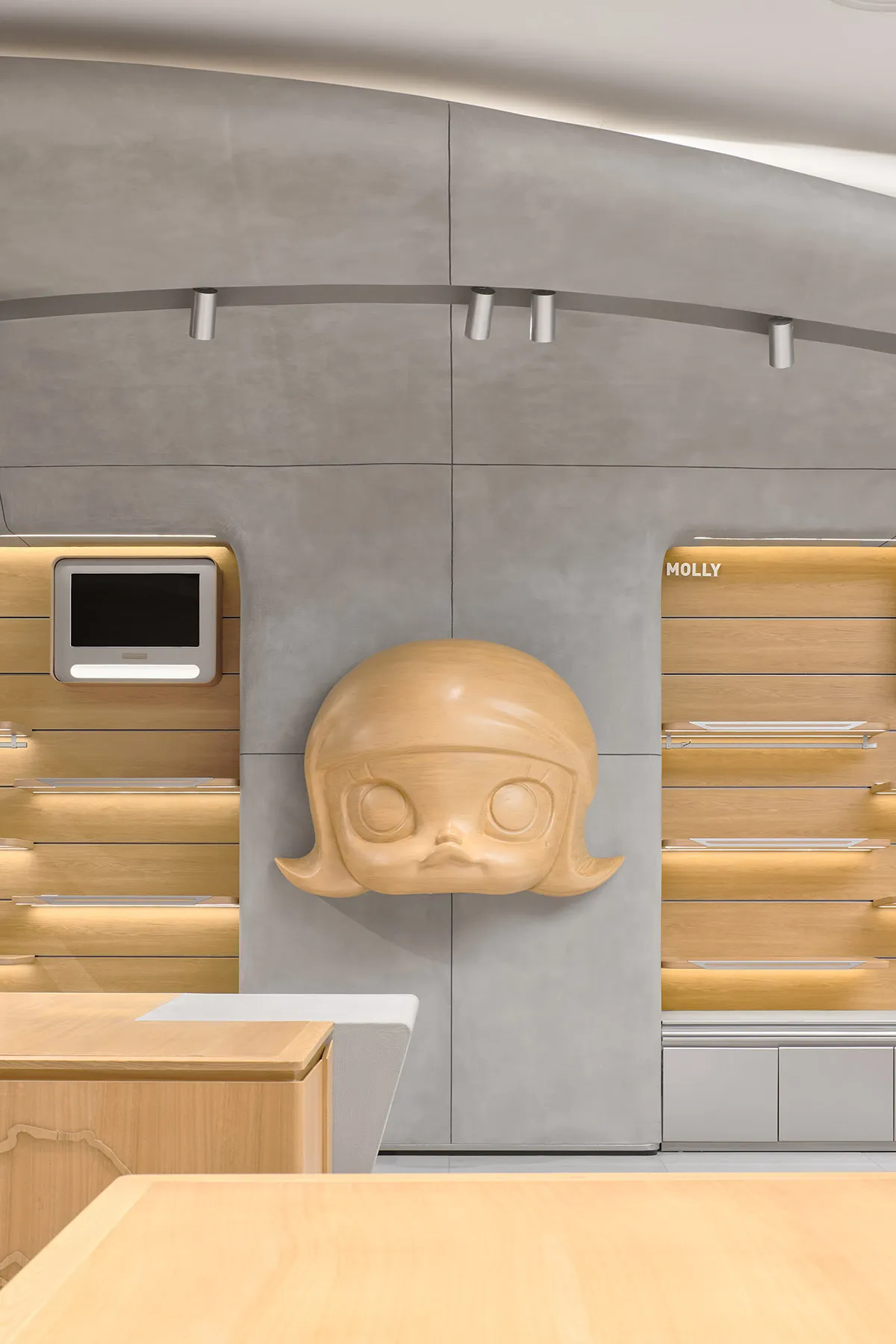 A modern retail storefront interior with a concrete wall and wooden shelves.