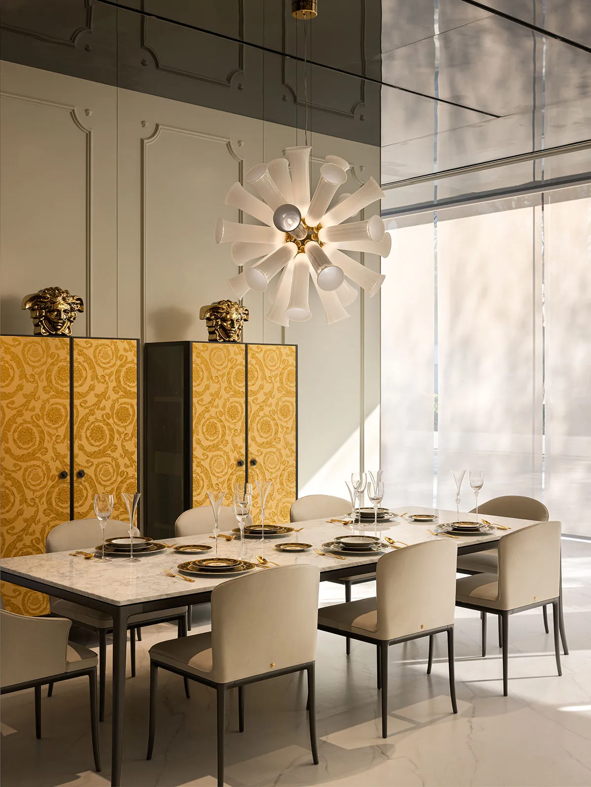 Modern dining room with a long table, chairs, and chandelier.