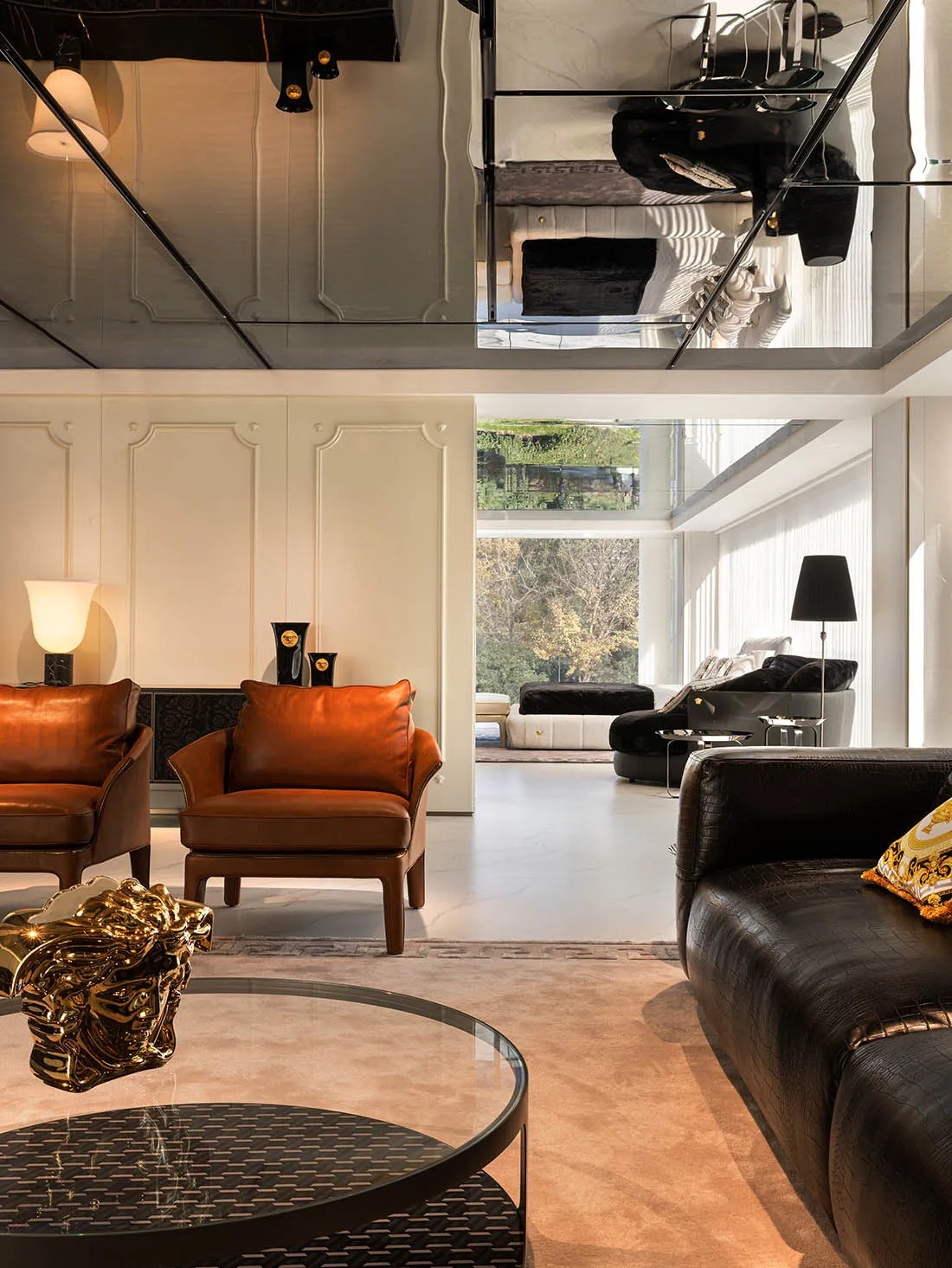 A modern living room featuring leather furniture and a glass coffee table.