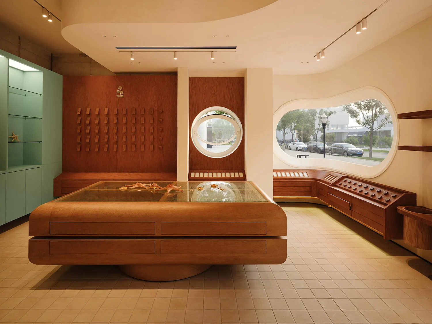 Modern retail shop featuring a large, wooden display table with starfish inside a retail environment.