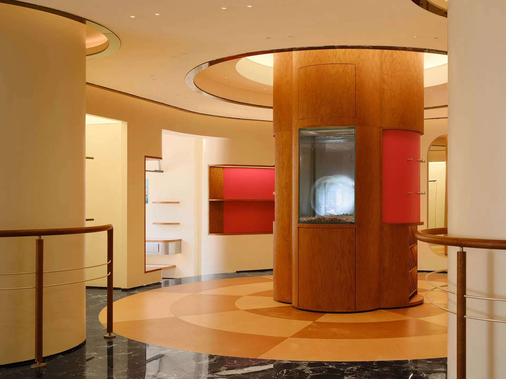 A modern retail store featuring wood finishes and a central aquarium.