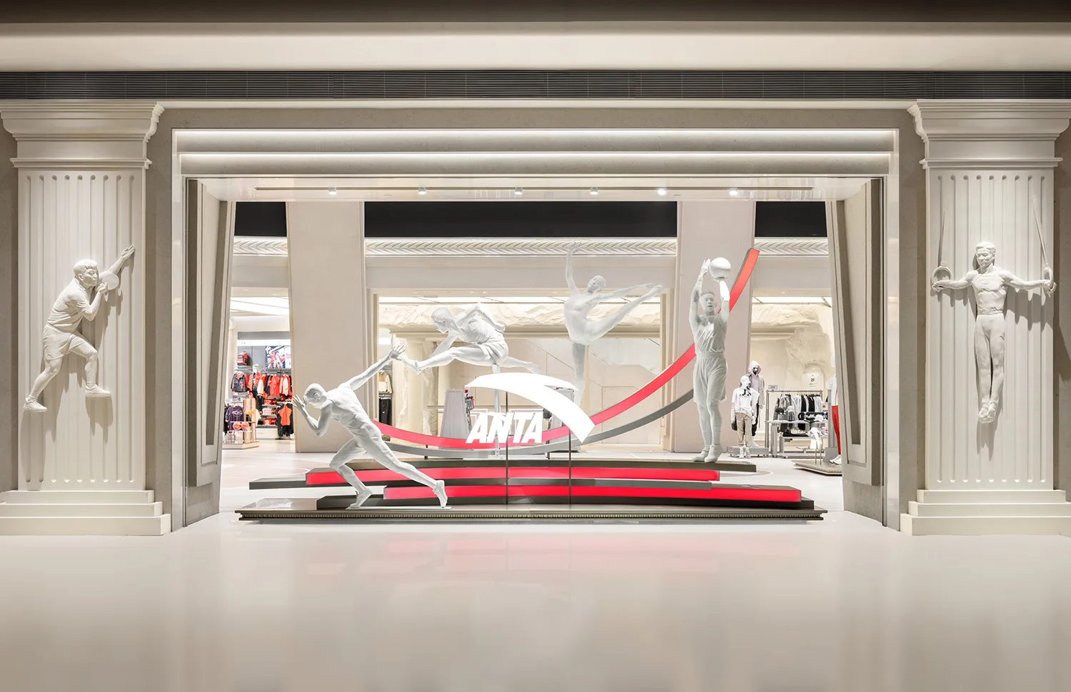 A retail display featuring statues in white, positioned to showcase a brand's sportswear.