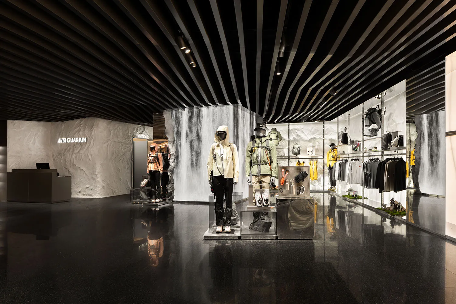 一間以混凝土材質打造的現代零售店,展示運動服飾與配件的人體模型。