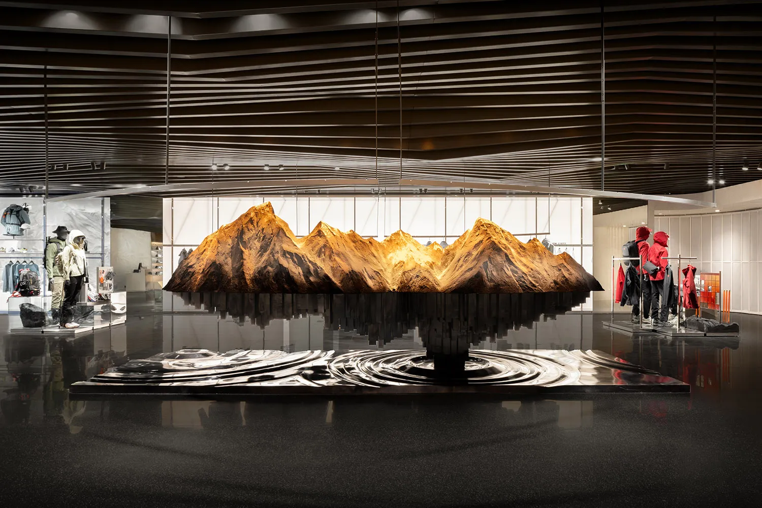 A modern storefront constructed from metal and glass, featuring a large model of mountains.
