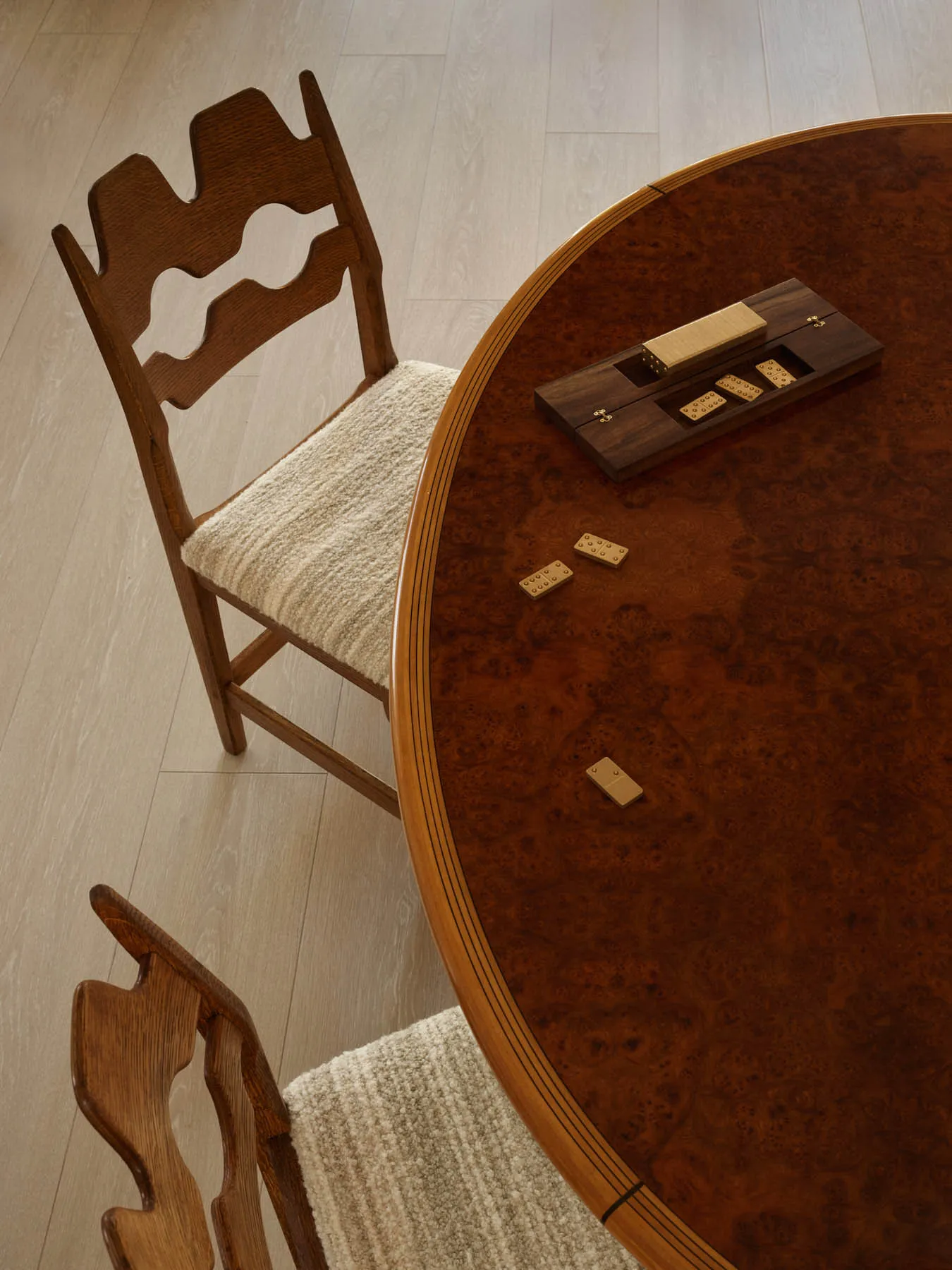 A close-up of a wooden dining table with two chairs next to it.