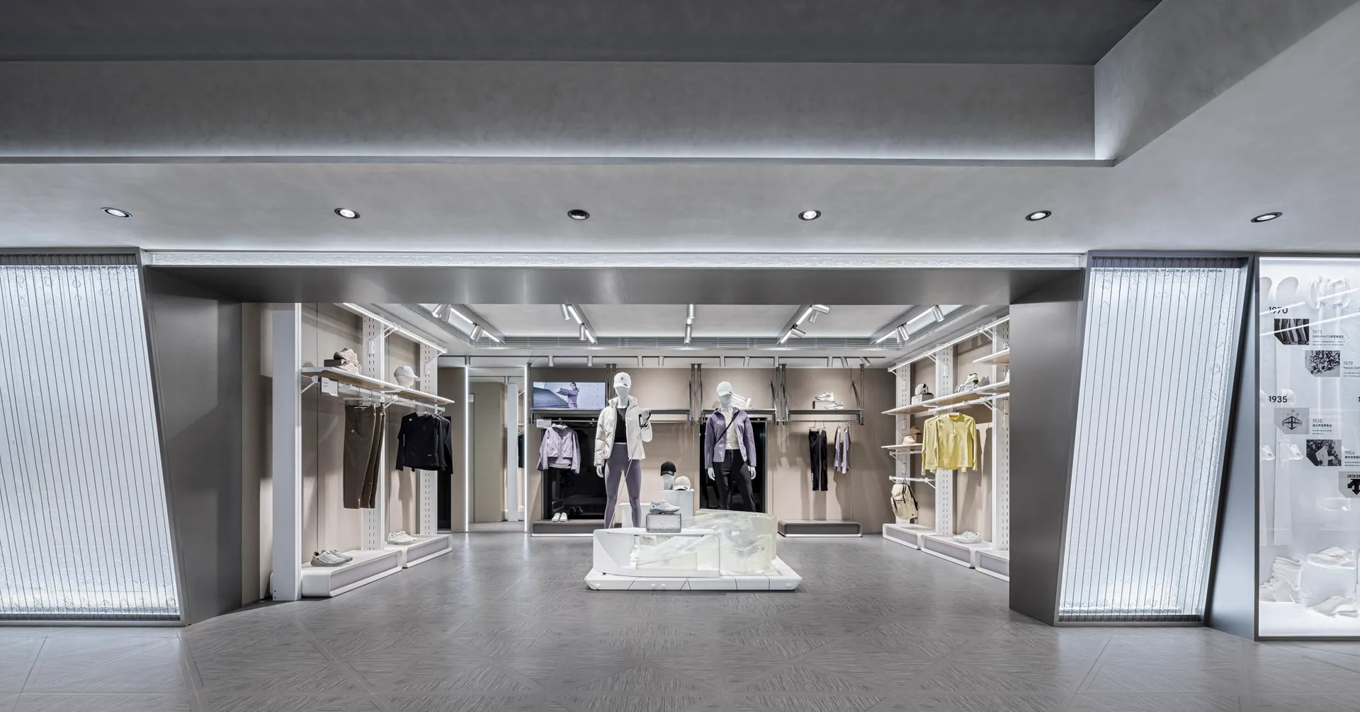 Modern retail store with concrete and metal interior, displaying clothing on mannequins.