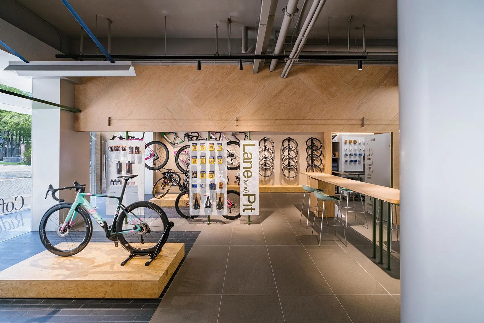 A modern bicycle shop with a concrete floor and walls, featuring a display of bicycles and an array of bike-related products.