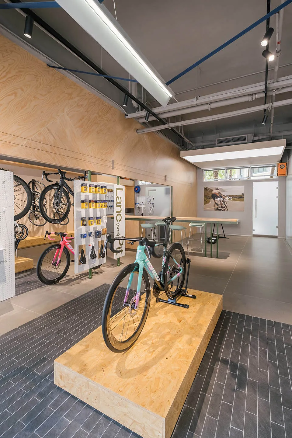 Modern interior of a bike shop featuring plywood, concrete, and steel elements.