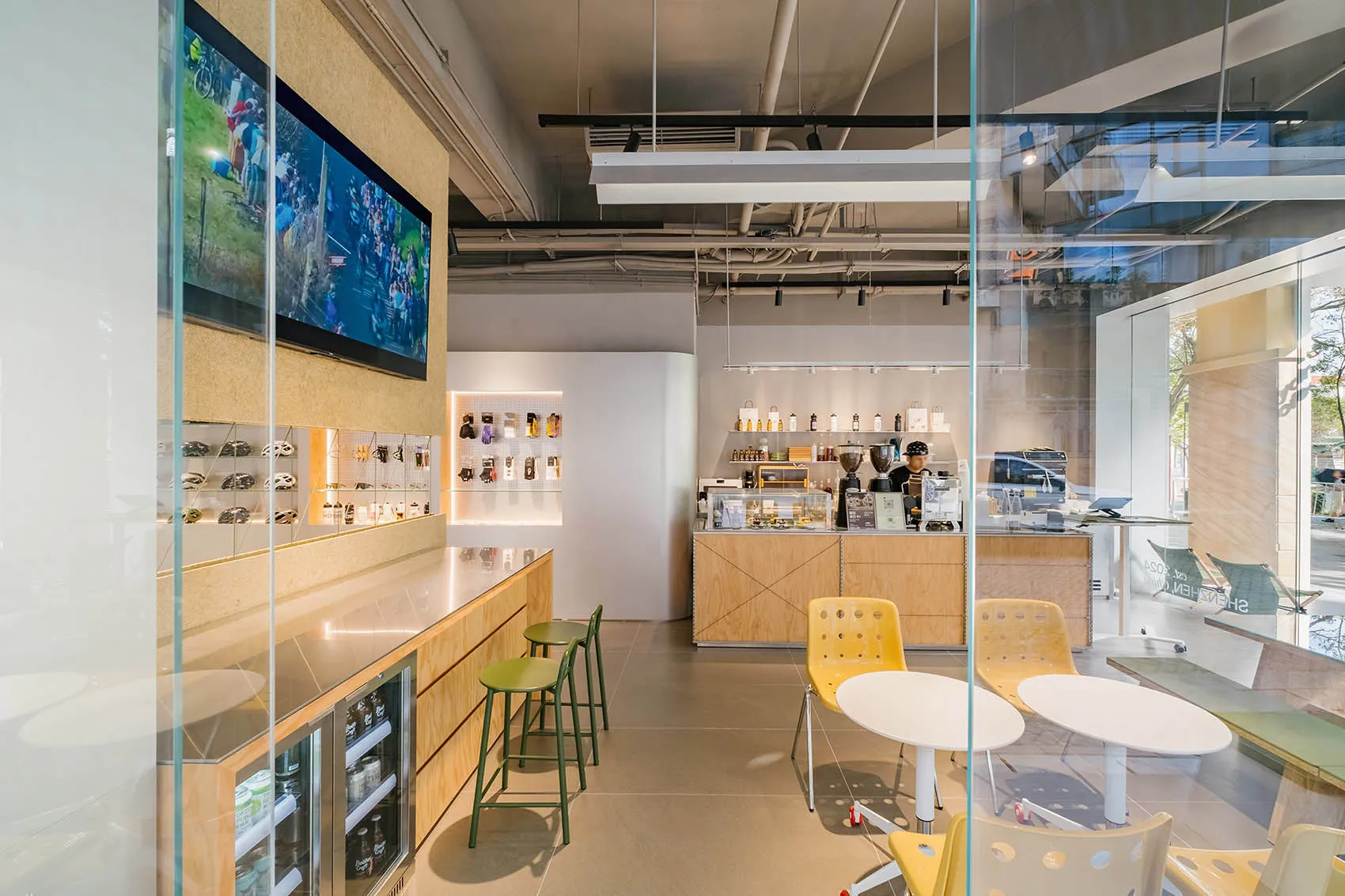 現代咖啡店，配有木質吧台、玻璃展示櫃與金屬椅。