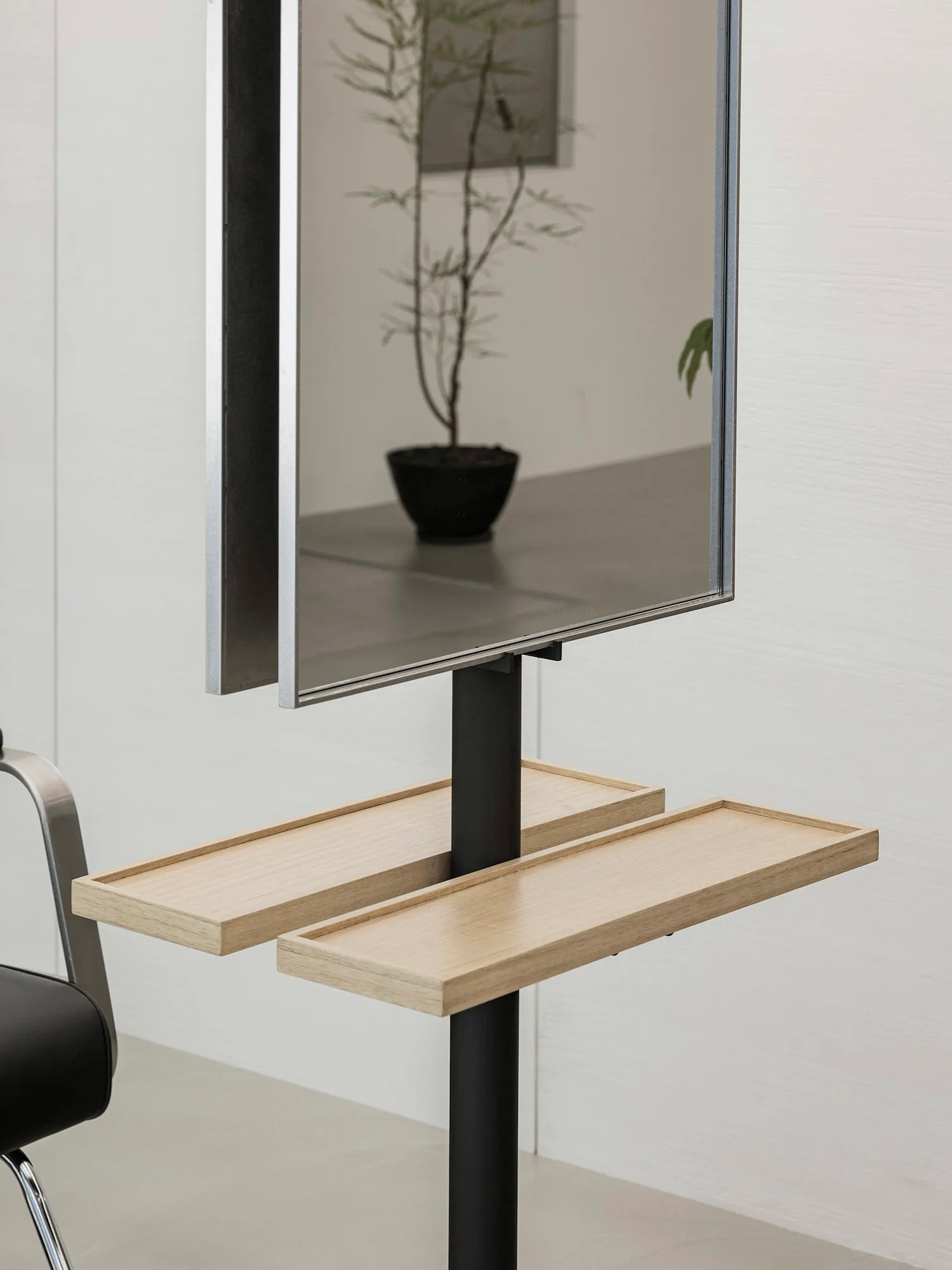 A modern floating desk with a white oak top and black base, featuring metal shelves with wood accents and a sleek, minimalist