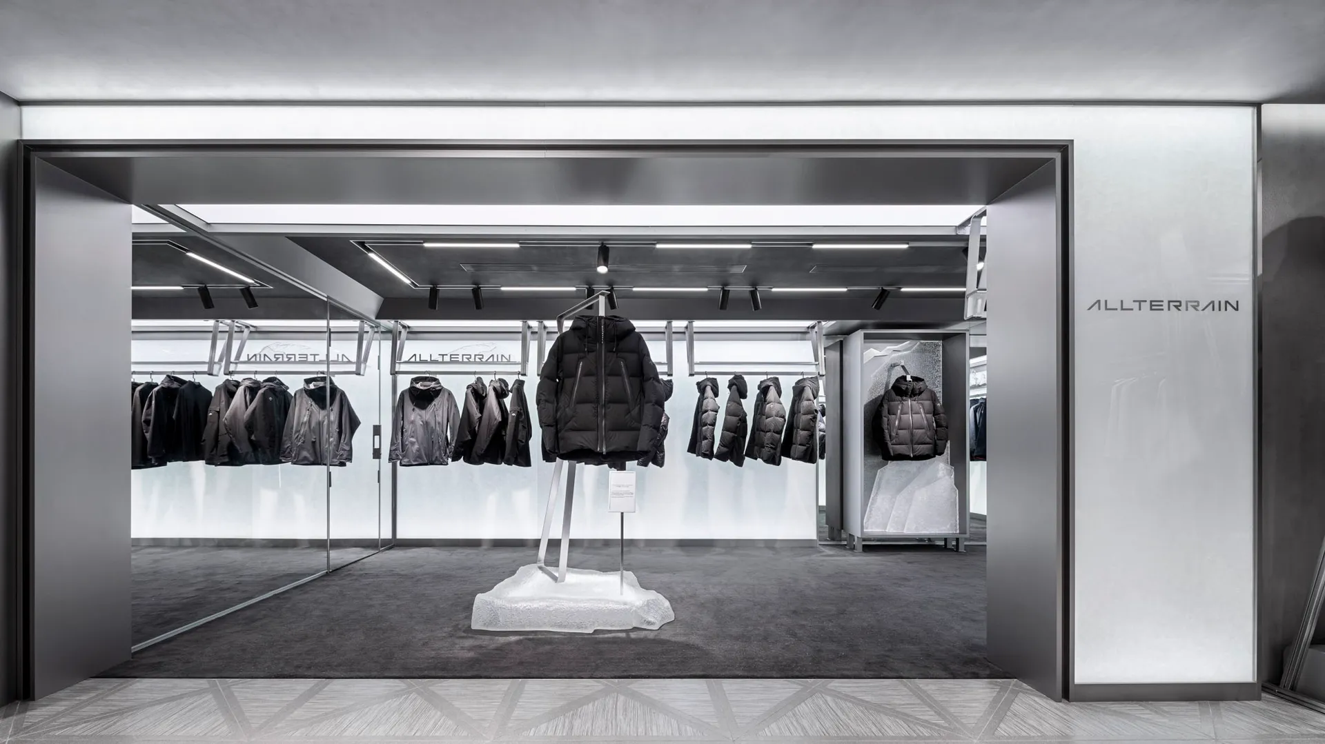 A retail storefront featuring glass and metal materials with a concrete base.