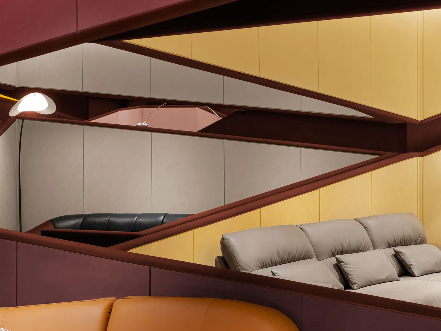 Modern leather couch with yellow walls and cushions.