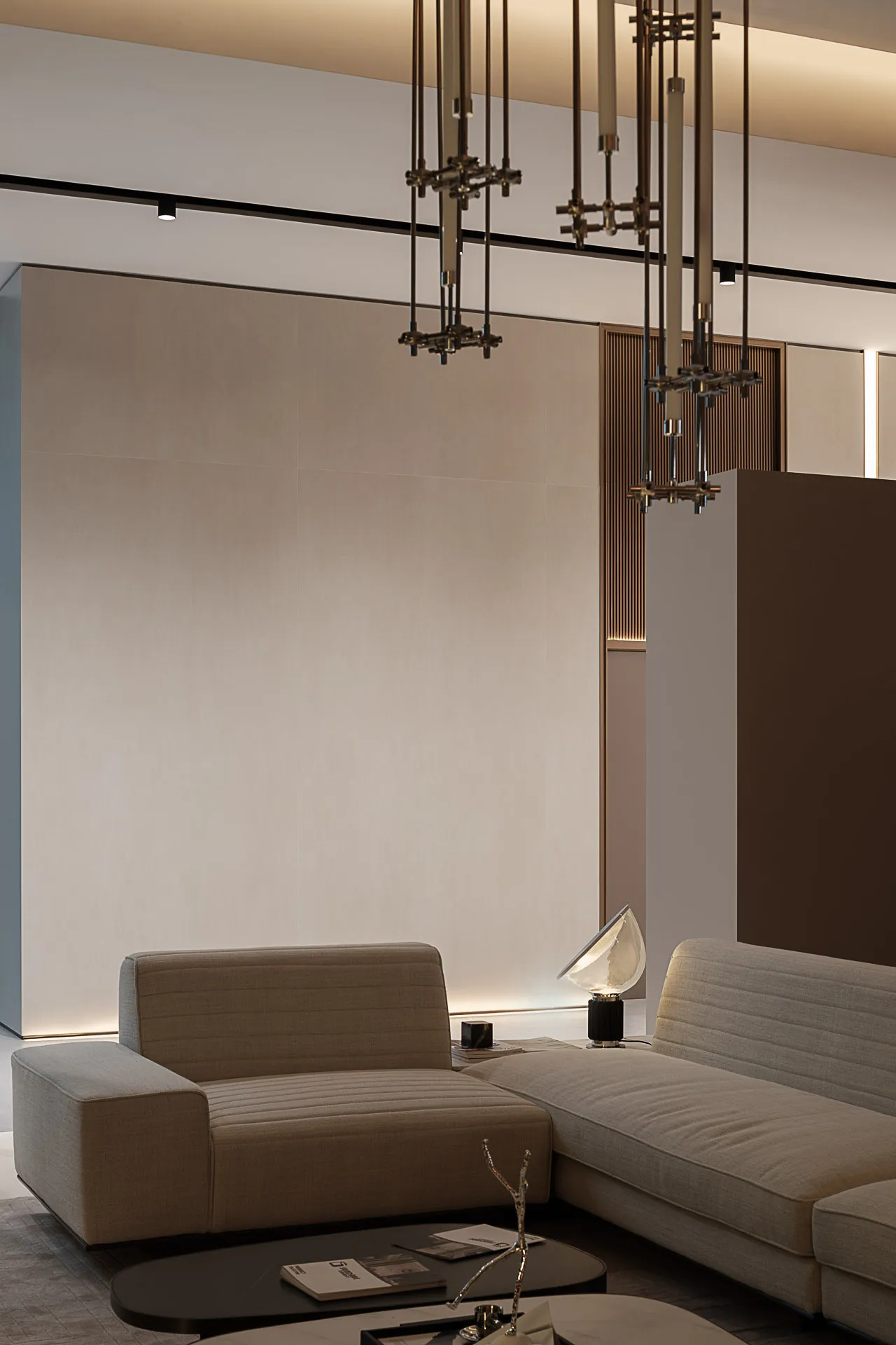 A modern living room featuring a beige textured couch with a sleek, metallic table lamp.