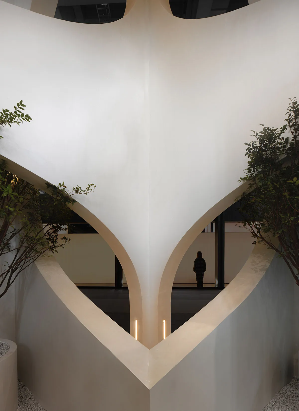 A modern interior space featuring concrete walls and archways.