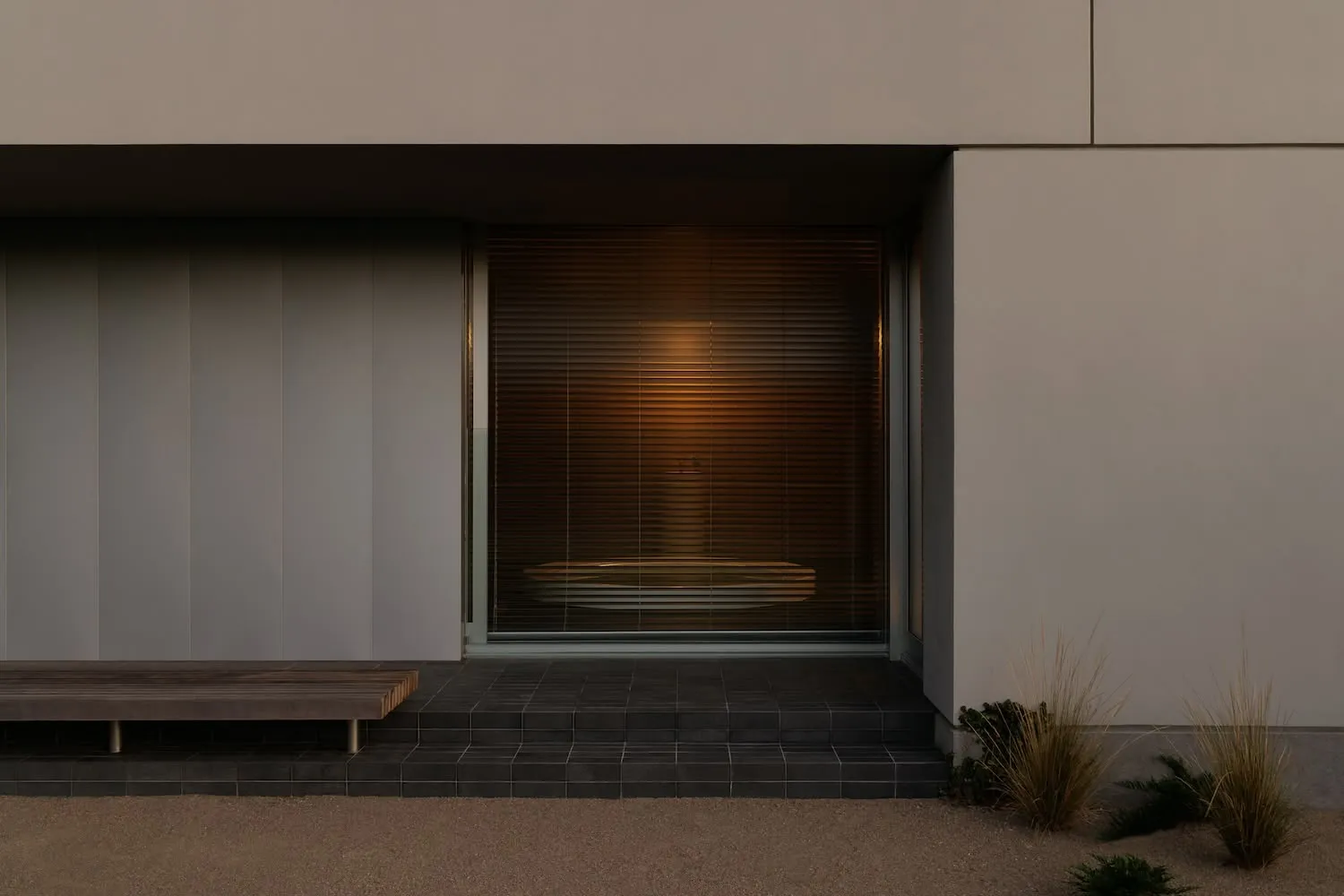 A modern minimalist entryway featuring concrete and glass materials.
