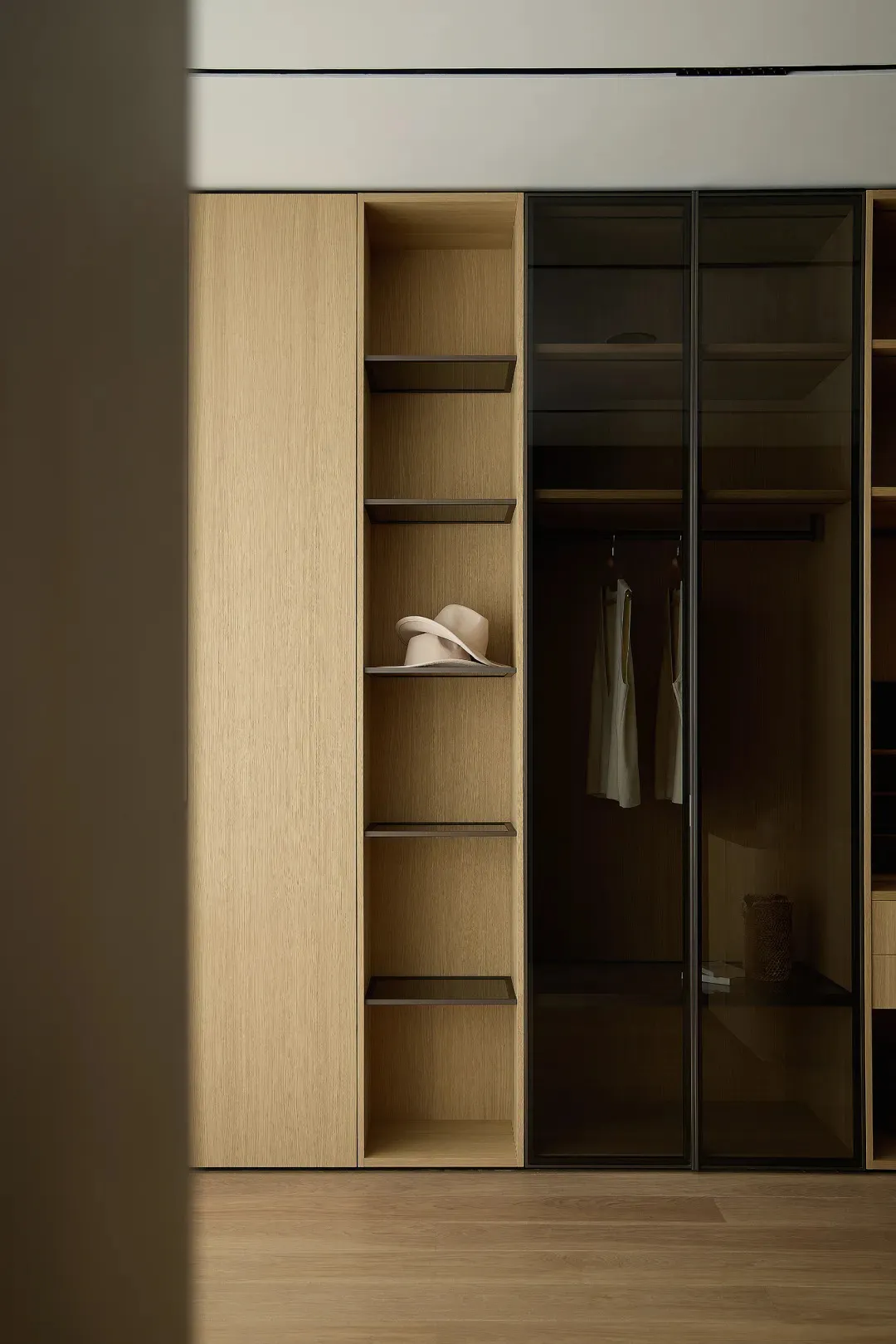 Modern, minimalist wardrobe with wooden shelves and glass doors.