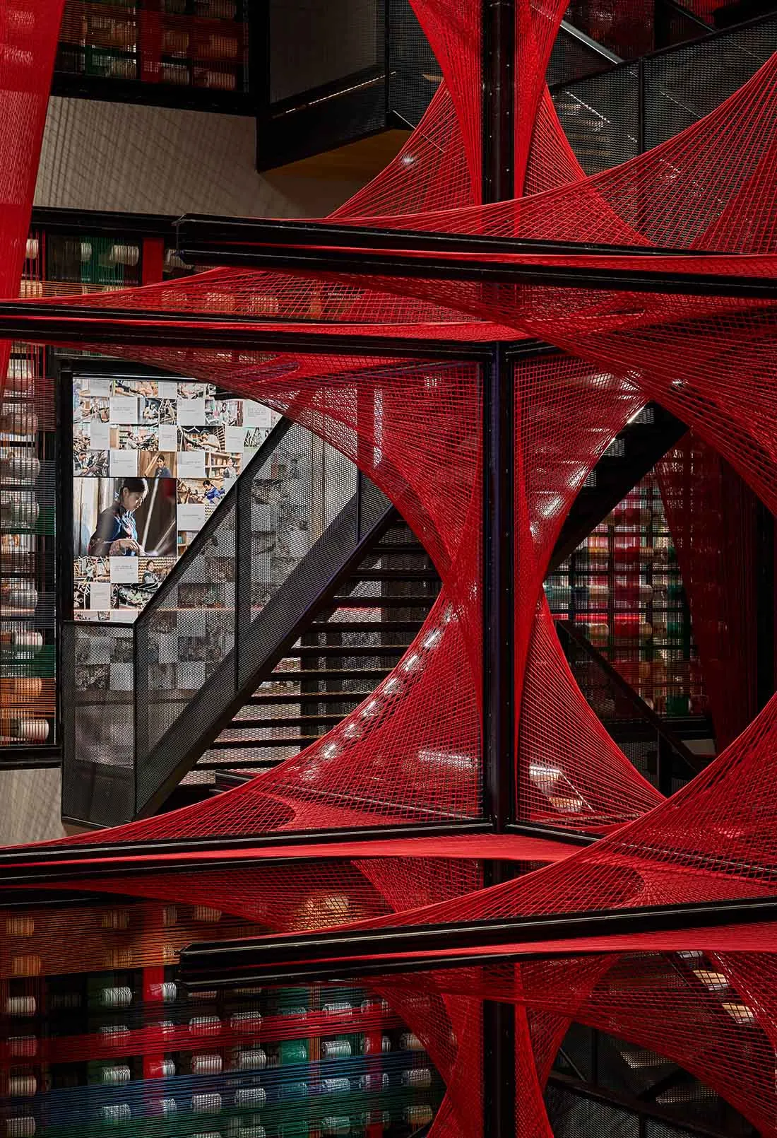 A red spider web installation in a modern interior space.